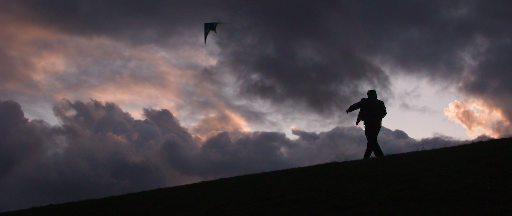 Everett Talvo flying a dual-line kite at Gasworks Park Seattle at dusk